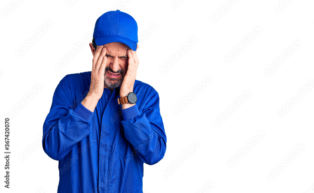 Middle age handsome man wearing mechanic uniform with hand on head, headache because stress. suffering migraine.