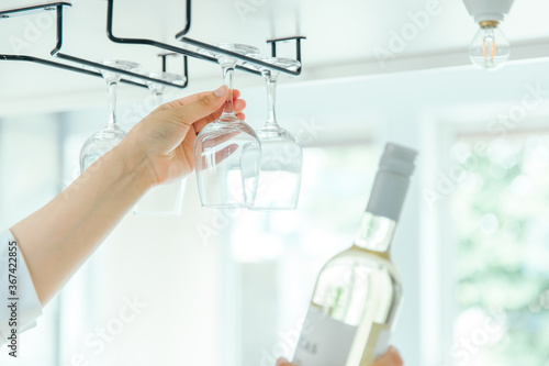 明るい部屋でグラスホルダーからワイングラスを取り出す wineglass glass