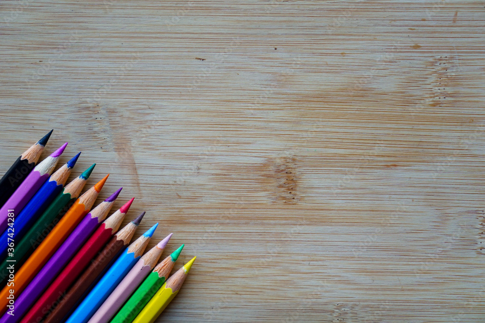 Obraz premium Arrange of pencils color and some origami paper with rustic wooden background. Back to school concept
