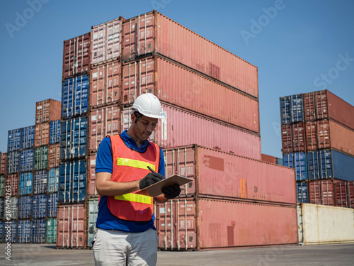 Foreman engineering import export shipping cargo technology logistic commercial site warehouse red and blue container is working and write report business