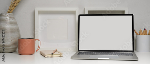 Home office desk with laptop, stationery and decorations on white table, clipping path.