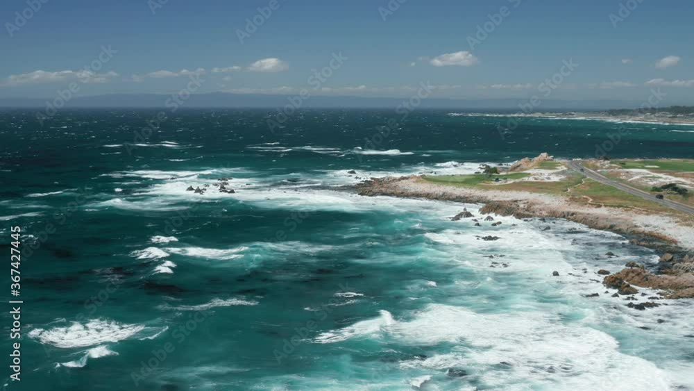 Beautiful teal Pacific ocean nature. Aerial view on green golf field with scenic landscape on background. 4K cinematic rocky coastline. Foaming waves crashing at ocean cliffs on sunny summer day Beautiful teal Pacific ocean nature. Aerial view on green golf field with scenic landscape on background. 4K cinematic rocky coastline. Foaming waves crashing at ocean cliffs on sunny summer day