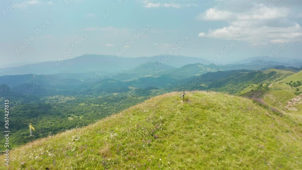 Amazing panoramic view of green mountain range in Kakheti region in Georgia. Passing by a cross on mountain top. Forward movement slight pan to left. 4k footage. Amazing panoramic view of green mountain range in Kakheti region in Georgia. Passing by a cross on mountain top. Forward movement slight pan to left. 4k footage.