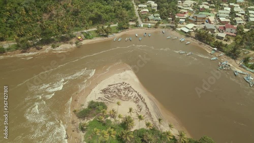 Descending aerial view of boats anchored off the fishing village of Mayaro, Trinidad photo