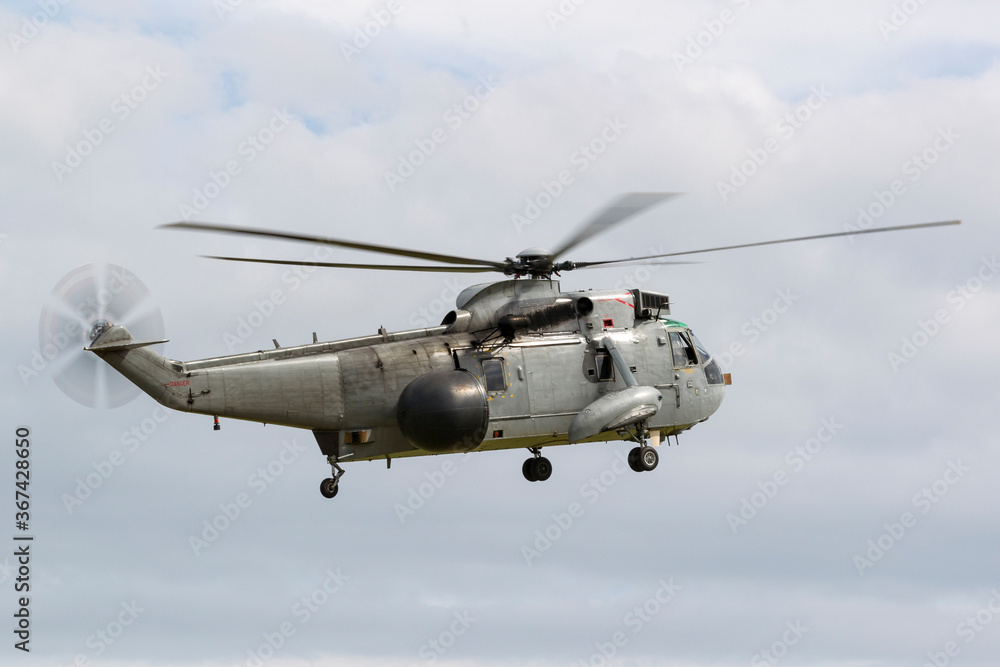 Navy helicopter used for surveillance and anti submarine warfare operations hovering on a cloudy day. Navy helicopter used for surveillance and anti submarine warfare operations hovering on a cloudy day.