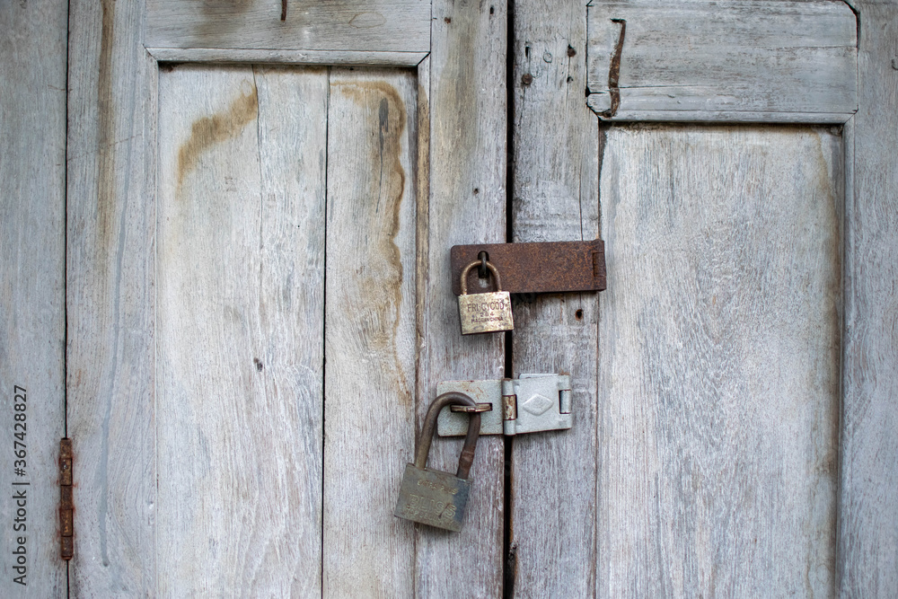Old hanging rusty iron lock on wooden door Old hanging rusty iron lock on wooden door
