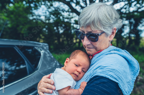 Grandmother with baby by a car