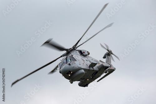 Fototapeta Naklejka Na Ścianę i Meble -  Grey military helicopter flying on an overcast day.