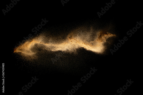 Abstract motion blurred brown sand background.Sandy explosion isolated on over dark background.