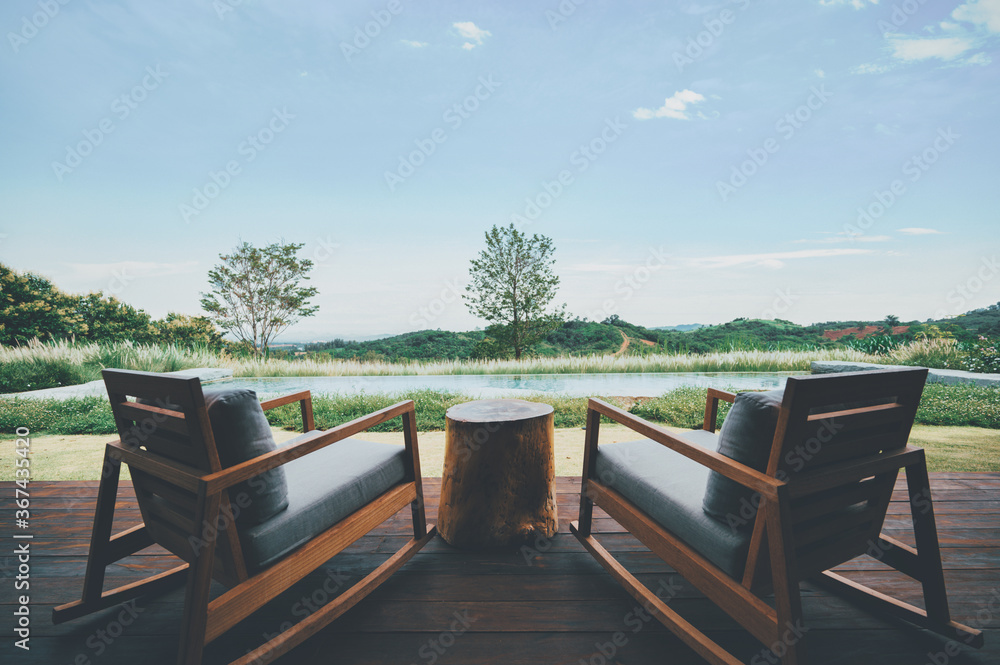 Two chairs for relaxing with deep green mountains and clear blue sky view