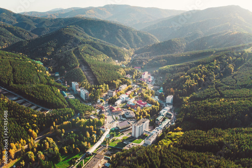 Aerial view of a small town in the Altai territory. Top view of the resort town Belokurikha. Bird's-eye view of the houses among the forests on the slopes of the mountains. photo