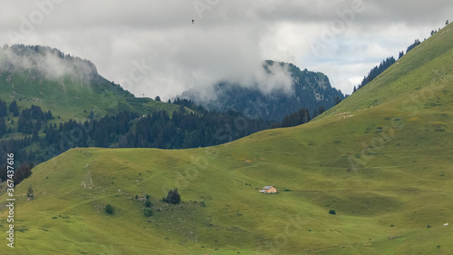 An isolated chalet in the Alps, near Morzine, in France, the mountain in spring, in the clouds 