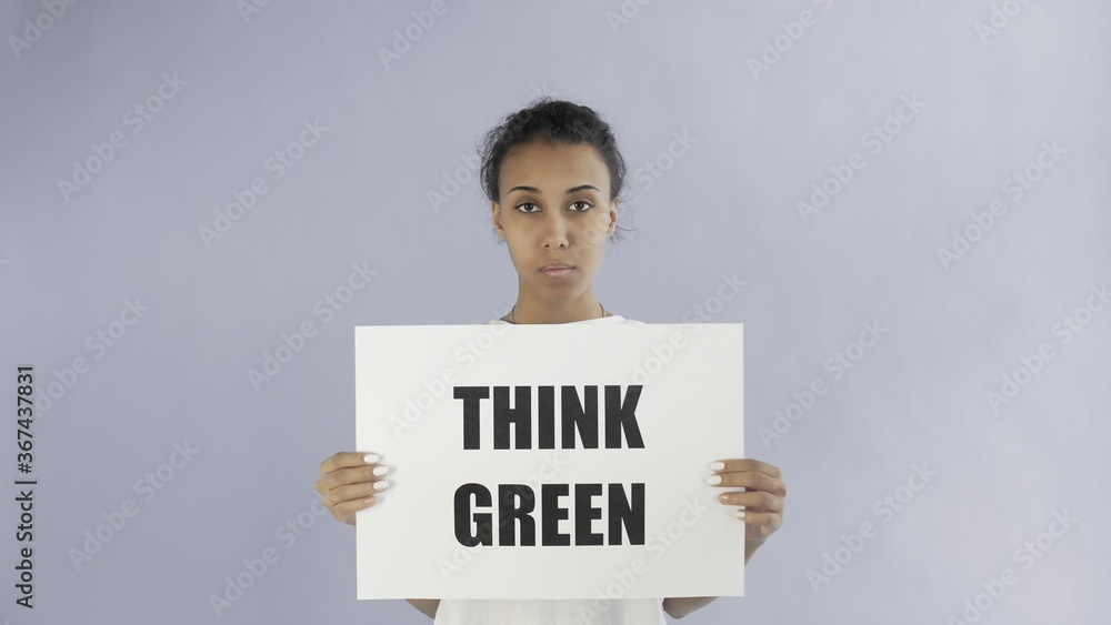 Afro-American Girl Activist With Think Green Poster on grey background Afro-American Girl Activist With Think Green Poster on grey background