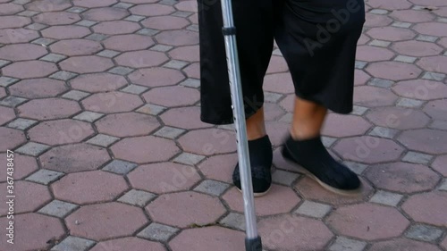 senior woman legs walking with walking stick