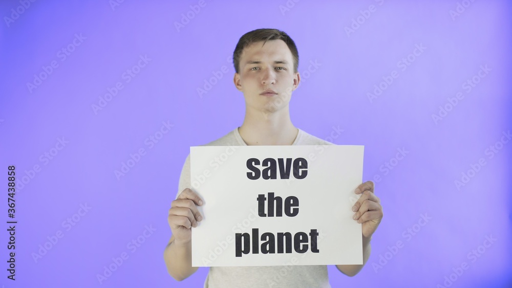 Young Man Activist With Save The Planet Poster on Violet background Young Man Activist With Save The Planet Poster on Violet background