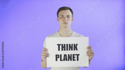 Young Man Activist With Think Planet Poster on Violet background