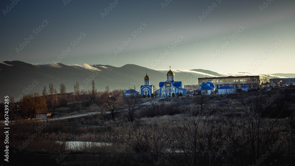 church against the backdrop of the rising dawn and mountains