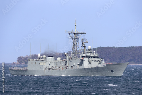 Navy warship heading into a harbor.