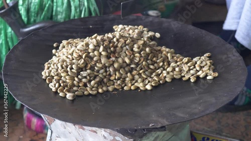 Coffee beans shot in an angle while being roasted, while the shop owner roasting them and turn them to the dark color from the green. photo