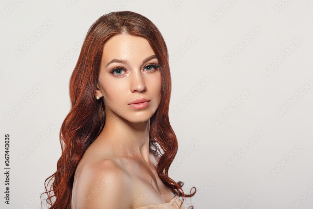 red-haired beautiful young woman on a light background