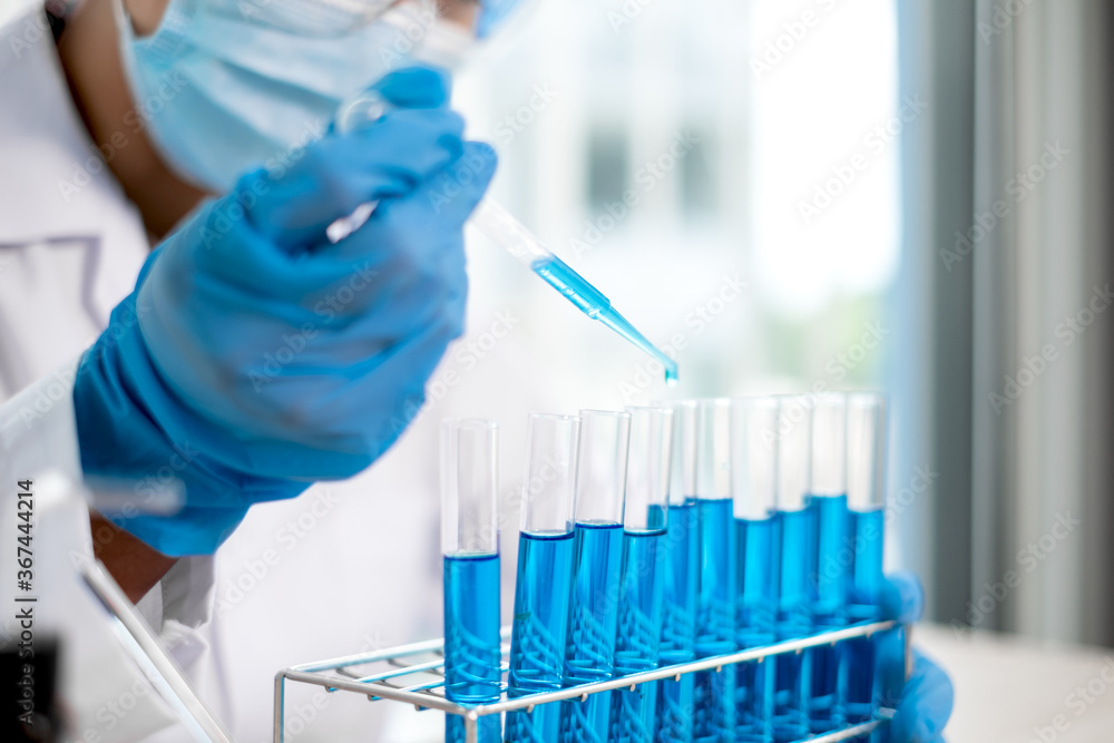 Medical scientists released a sample pipette into a test tube to analyze the virus in a chemical laboratory. Scientific research concepts
