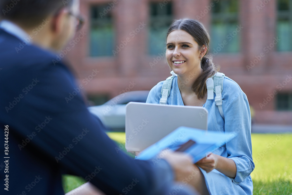 Couple of students in the campus studying outdoors Couple of students in the campus studying outdoors