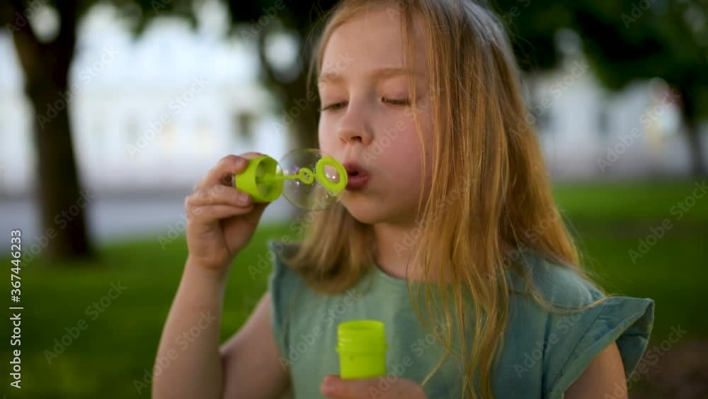 Pretty young girl blowing soap bubbles on a sunset Pretty young girl blowing soap bubbles on a sunset