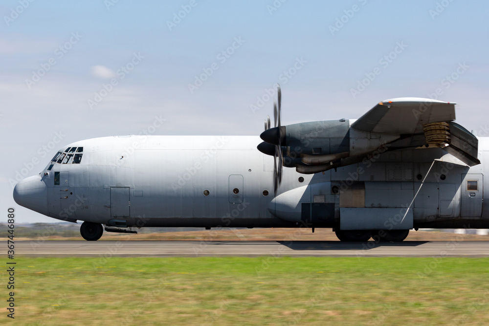 Military cargo airplane rolling down a runway in preparation for takeoff. Military cargo airplane rolling down a runway in preparation for takeoff.