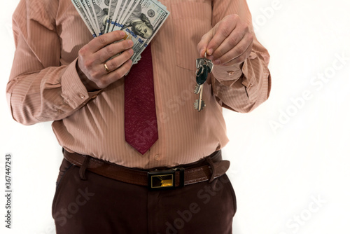 Businessman holding dollars and apartment keys isolated on white. Renting or buying a home. Money