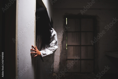 Billede på lærred Mysterious Woman, Horror scene of scary ghost woman hiding behind the door of ol