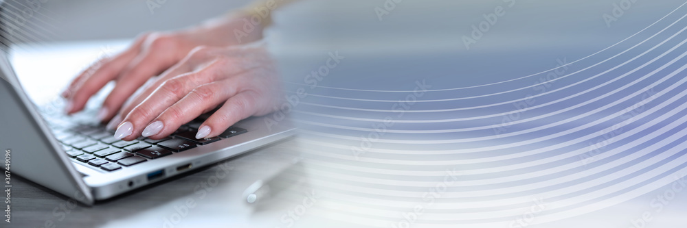 Female hands working on laptop; panoramic banner Female hands working on laptop; panoramic banner