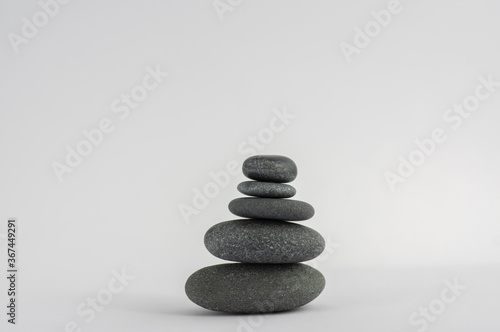 One simplicity stones cairn isolated on white background  group of five black pebbles in tower