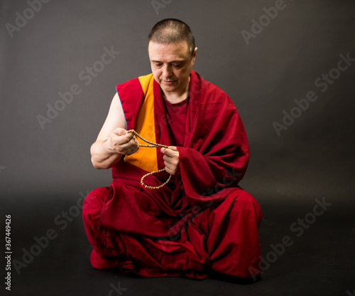 Tablou canvas Tibetan Buddhist monk teacher in a burgundy yellow outfit suit