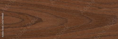 Expensive natural nut veneer background in dark brown color. Natural wood texture  pattern of a long veneer sheet.