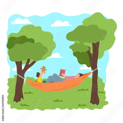 Mother and son relaxing in hammock together during recreation on nature
