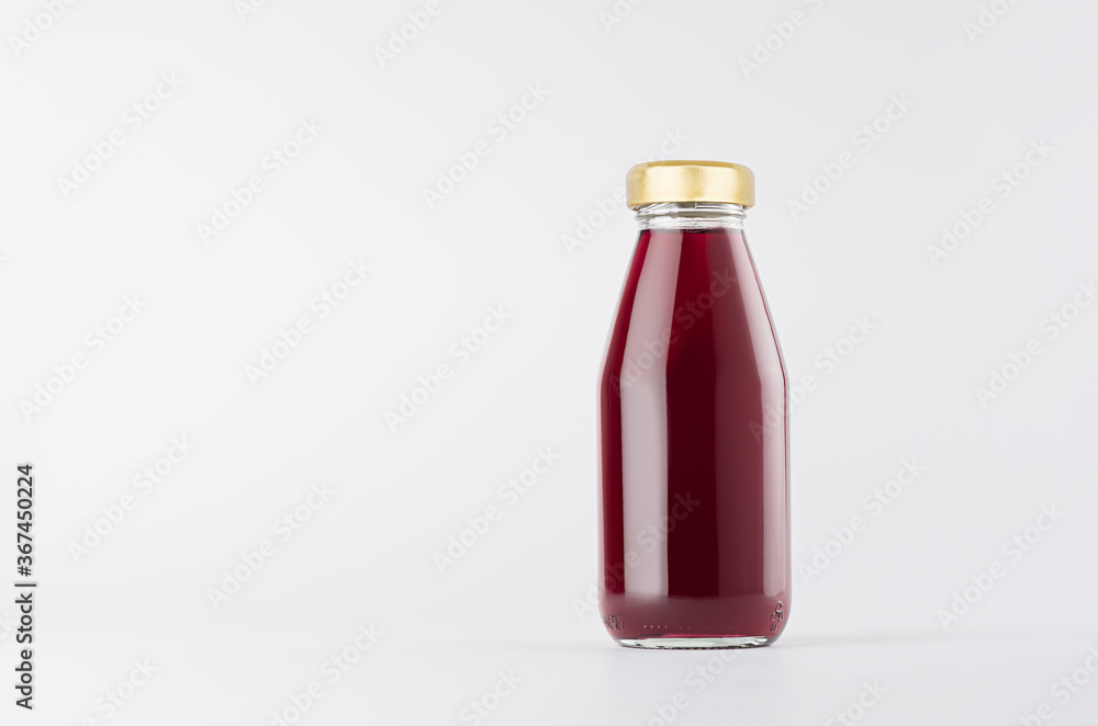 Violet berries juice in glass bottle with gold cap and white blank label mock up on white background with copy space, template for packaging, advertising, design product, branding.