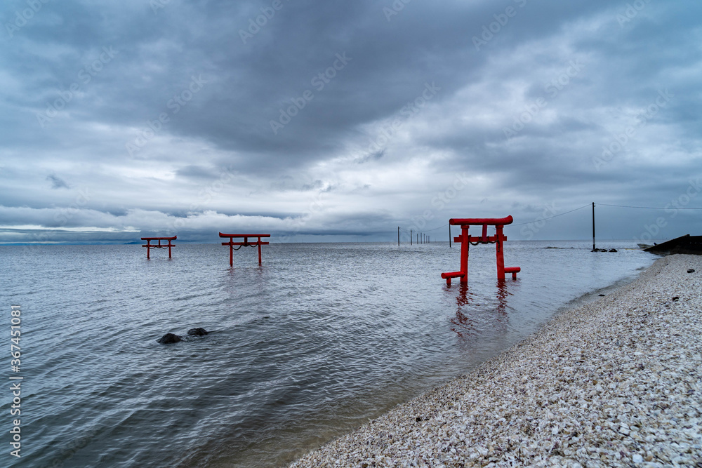 Seascape with shrine gate in cloudy morning in Japan.