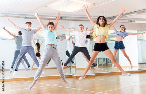 Group of cheerful tweens jumping during modern dances class