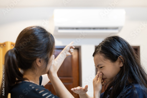 Quadro em tela Asian woman and child girl are closing her nose, bad smell,musty smell of air co