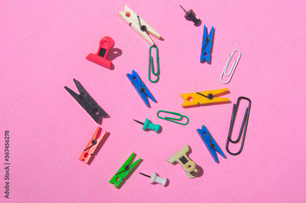 Office supplies scattered on a pink surface