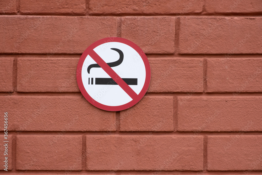No smoking sign on a red brick wall. Copy space. No smoking sign on a red brick wall. Copy space.