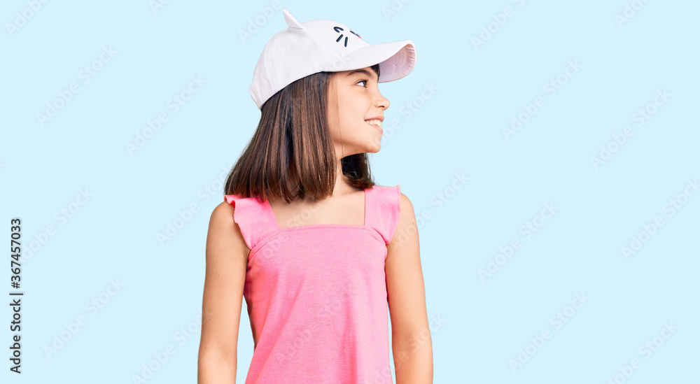 Young little girl with bang wearing funny kitty cap looking away to side with smile on face, natural expression. laughing confident. Young little girl with bang wearing funny kitty cap looking away to side with smile on face, natural expression. laughing confident.