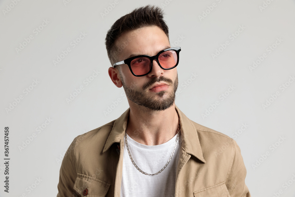reflective unshaved guy wearing sunglasses and looking to side reflective unshaved guy wearing sunglasses and looking to side