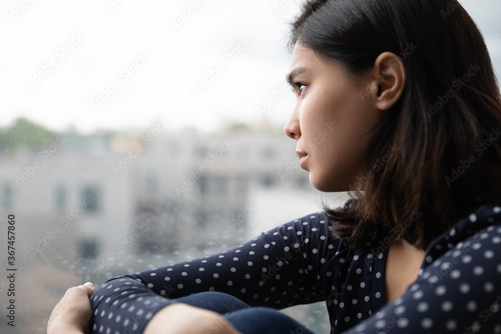 Sad Asian millennial girl look in window distance thinking or pondering alone at home, thoughtful upset unhappy Vietnamese woman lost in thoughts dreaming, feel lonely distressed, loneliness concept - obrazy, fototapety, plakaty 