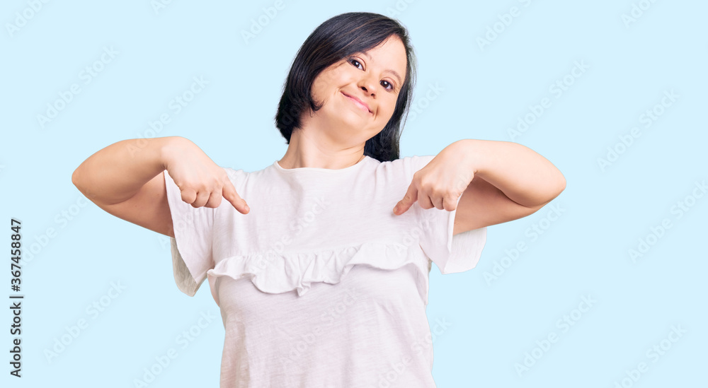 Brunette woman with down syndrome wearing casual white tshirt looking confident with smile on face, pointing oneself with fingers proud and happy. Brunette woman with down syndrome wearing casual white tshirt looking confident with smile on face, pointing oneself with fingers proud and happy.