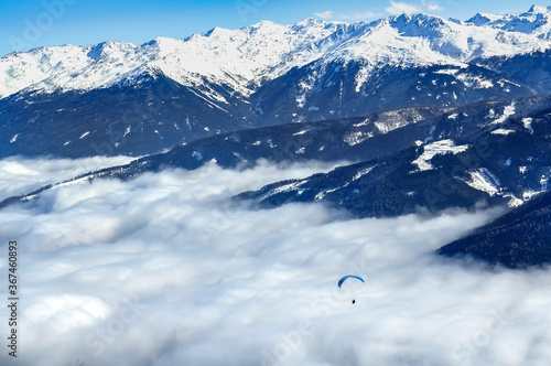 Paraplan flying in the snowy Alps. Magnificent view.