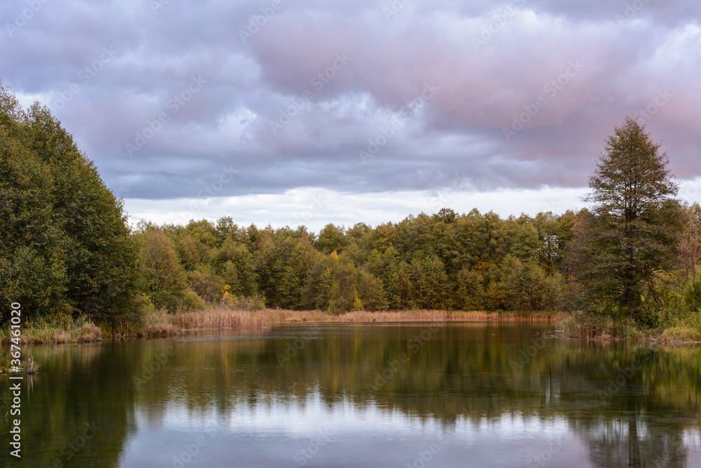 The reeds, grass, trees and turquoise water of a healing lake. Autumn landscape. Early autumn morning on the Blue Lake in Kazan.