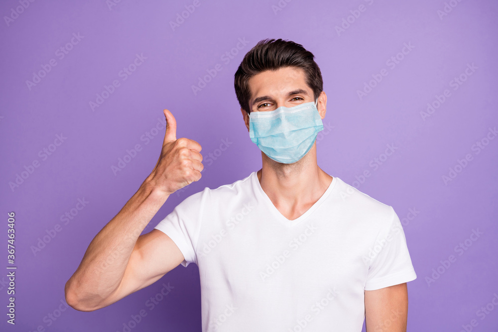 Close-up portrait of his he nice attractive healthy guy wearing safety gauze mask showing thumbup influenza preventive measures isolated bright vivid shine vibrant lilac violet purple color background Close-up portrait of his he nice attractive healthy guy wearing safety gauze mask showing thumbup influenza preventive measures isolated bright vivid shine vibrant lilac violet purple color background