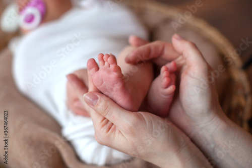 Newborn baby feet in father hands. Family concept. Props for little baby photoshoot. 