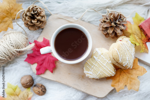 Cup of coffee, autumn leaves, cones, cookies on the white table. Autumn concept.
